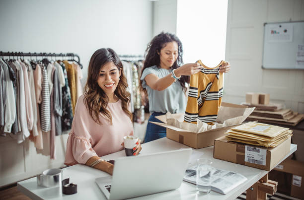 Small business owners Working women at their store. They wearing casual clothing, accepting new orders online and packing merchandise for customer cardboard box photos stock pictures, royalty-free photos & images