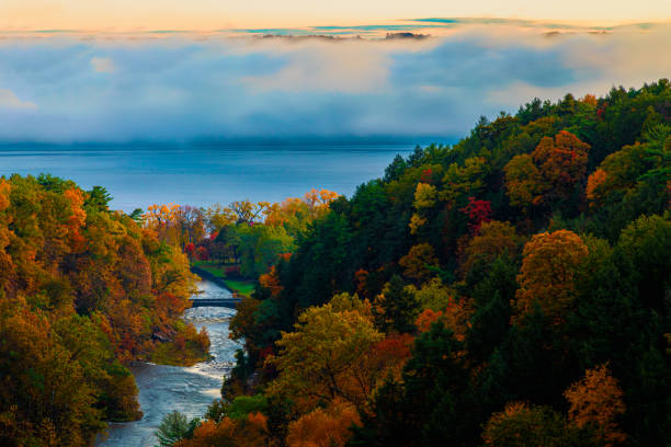 Taughannock Falls Gorge and Creek at Sunrise In Full Fall Colors On Foggy Day Overlooking Lower falls and Cayuga Lake Taughannock Falls State Park Trumansburg Ulysses Ithaca NY Finger Lakes Upstate New York Empire State finger lakes stock pictures, royalty-free photos & images
