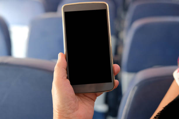 istock hand holding mobile smart phone on airplane 1184268675