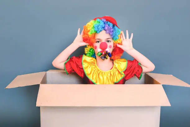 Photo of Girl in a clown suit in a wig is teased at camera