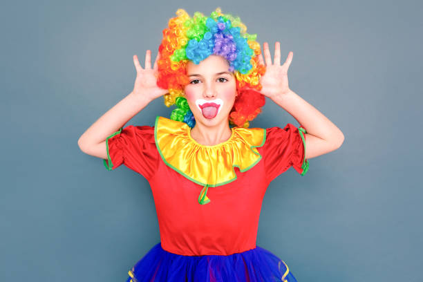 istock Girl in clown comic suit teased at camera 1184269107