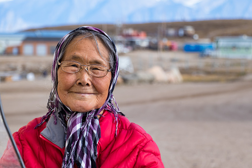 Pond Inlet, Baffin Island, Canada - August 23, 2019: Portrait of an Inuit senior woman outdoors in Pond Inlet, Baffin Island, Canada.