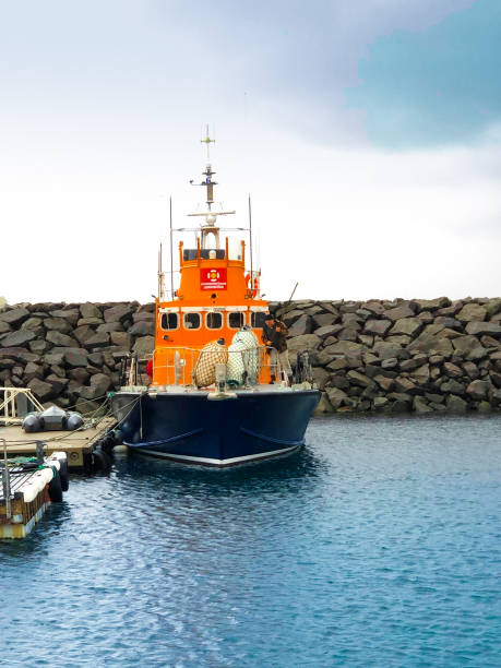 Rif, Iceland: A fisherman working on an orange trawler in the harbor of Rif, a fishing village next to Hellissandur on the north coast of the Snaefellsnes Peninsula in West Iceland.