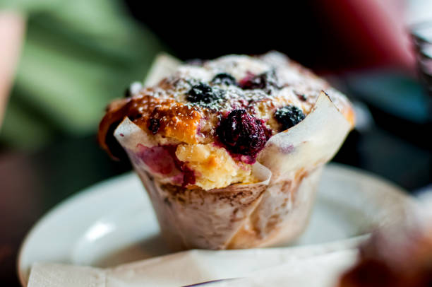делиозный ягодный кекс на тарелке. завтрак в кафе - muffin cake cupcake blueberry muffin стоковые фото и изображения
