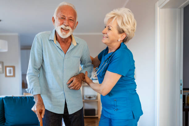 istock Female nurse supporting senior man to walk 1184277901