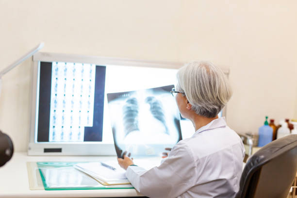 istock Senior Female Doctor Looking at Xrays in Her Office 1184282755