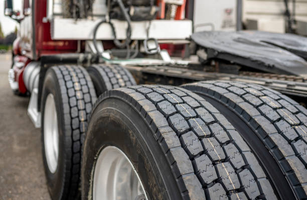 ruote con pneumatici su assi di grande carro semi-camion in piedi sul parcheggio - truck tire foto e immagini stock