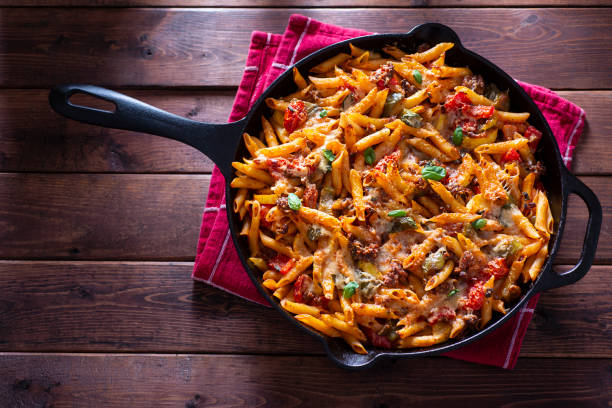 Baked Pasta Skillet Healthy Pasta in Cast Iron Skillet with Tomato, Basil, Bell Pepper, Onion, Garlic and Parmesan Cheese POT NOODLE stock pictures, royalty-free photos & images