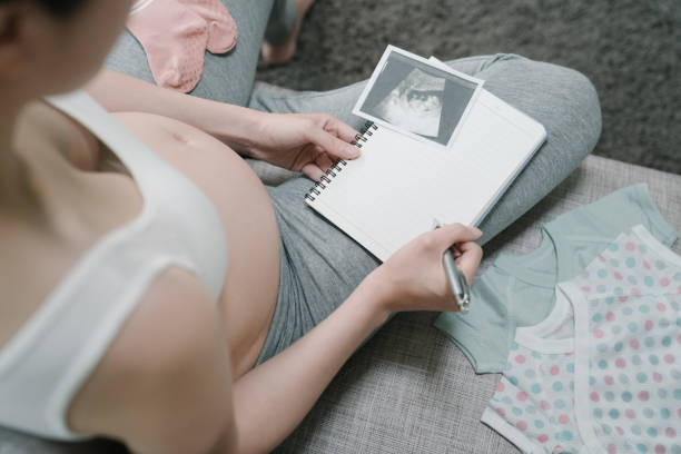 istock expecting mother with nake tummy writing note 1184284131