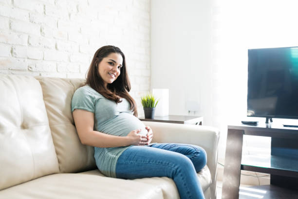 istock Pretty Pregnant Female Sitting While Touching Her Abdomen 1184284751