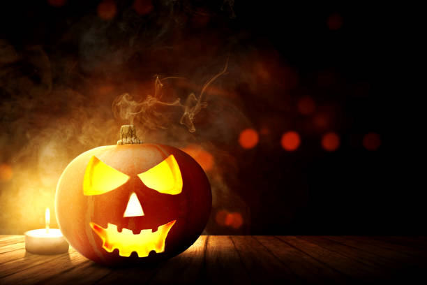 istock Jack-o-Lantern and candle on wooden table 1184285871