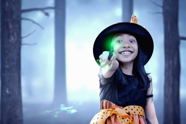 istock Asian witch little girl using the wand with a magic shine 1184286068
