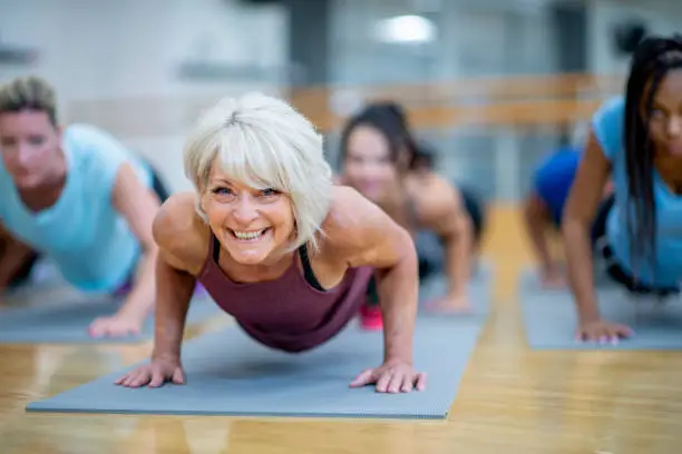 Photo of Senior Woman in Fitness Class in a Plank Pose Smiling stock photo