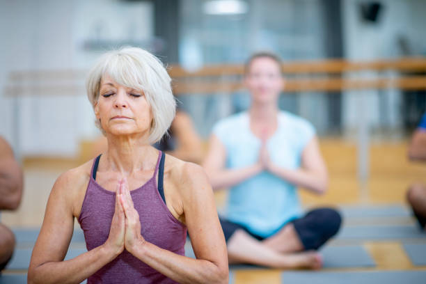 adult co-ed yoga class stock photo - women yoga yoga class mature adult imagens e fotografias de stock