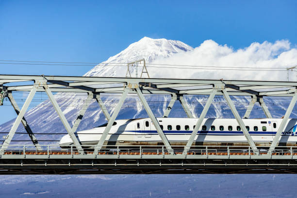 High Speed Bullet Train and Fuji Mountain, Shizuoka, Japan High Speed bullet Train across Fuji River Bridge with Fuji Mountain Background in Winter bullet train mount fuji stock pictures, royalty-free photos & images