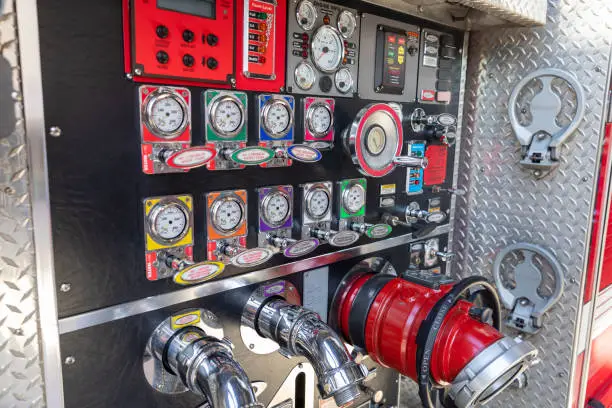 Valaves and pump panel on the side  of a red fire truck