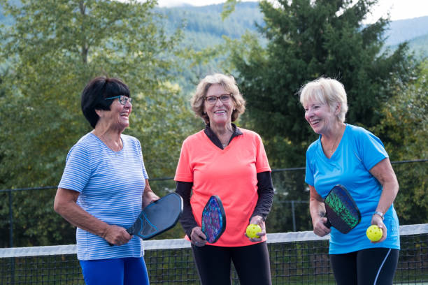 Active seniors bonding at the tennis court stock photo