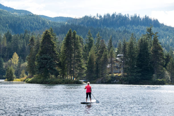 istock Active senior woman paddle boarding on vacation 1184295075