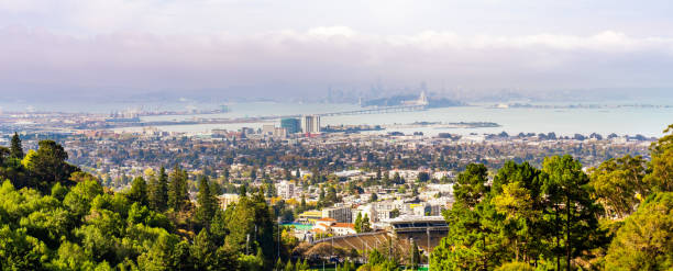 Panoramic view of Berkeley; San Francisco Bay shoreline with Port of Oakland, Yerba Buena Island, Treasure Island, the Bay bridge and the San Francisco skyline visible in the background; California Panoramic view of Berkeley; San Francisco Bay shoreline with Port of Oakland, Yerba Buena Island, Treasure Island, the Bay bridge and the San Francisco skyline visible in the background; California berkeley california stock pictures, royalty-free photos & images