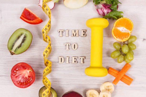 istock Dumbbell, centimeter and nutritious food as source natural vitamins, healthy nutrition and slimming concept 1184301370