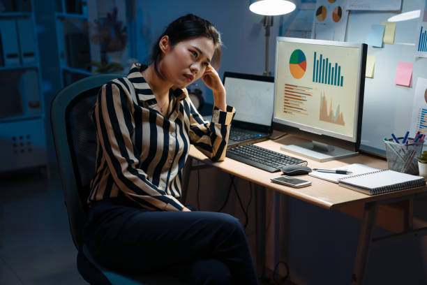 istock pensive woman in night workplace 1184302823