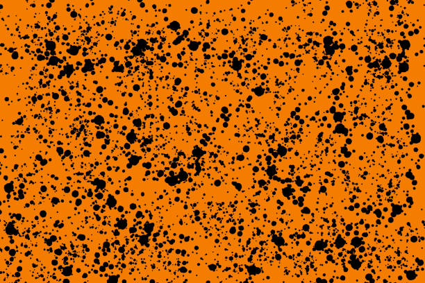 Bright black random round paint splashes on orange background. Abstract colorful texture.