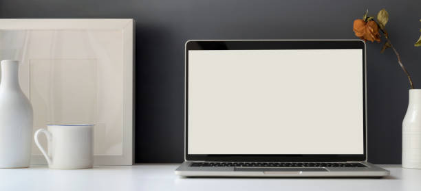 istock Minimal office room with open blank screen laptop computer with mock up frame 1184306060