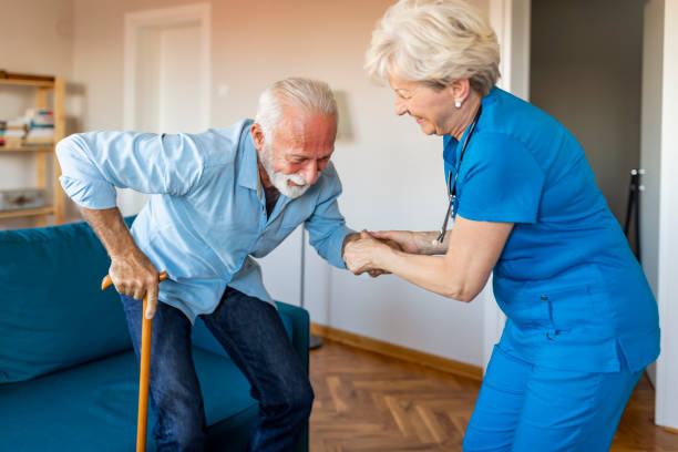 istock Female nurse supporting senior man to walk 1184318733