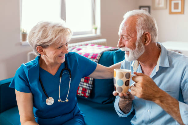 badante donna che serve tè pomeridiano alla pazienza - geriatric nurse foto e immagini stock