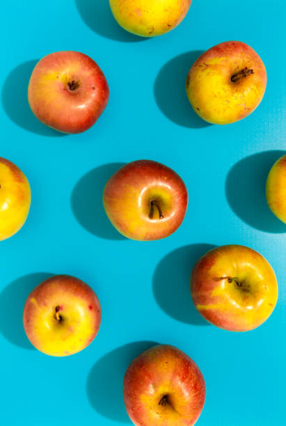 istock Apples with hard shadow on blue background, flat lay image. 1184328838