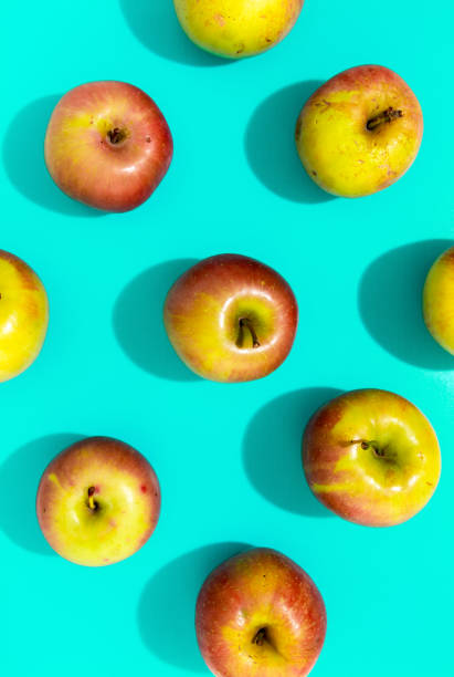 istock Apples with hard shadow on aqua background, flat lay image. 1184328843