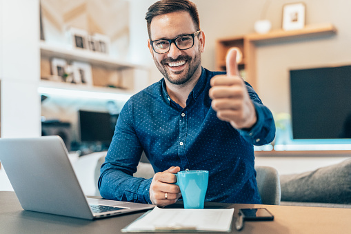 Young businessman working at home using lap top