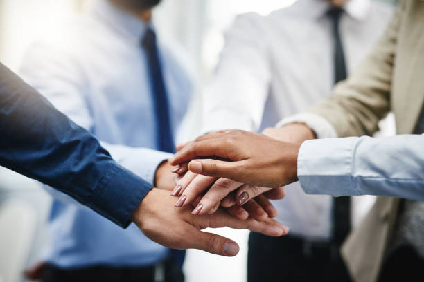 We can do this! Cropped shot of an unrecognizable group of businesspeople standing in the office together with their hands stacked stacked hands photos stock pictures, royalty-free photos & images