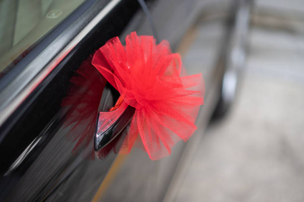 istock Red ribbon decoration on wedding car 1184337214