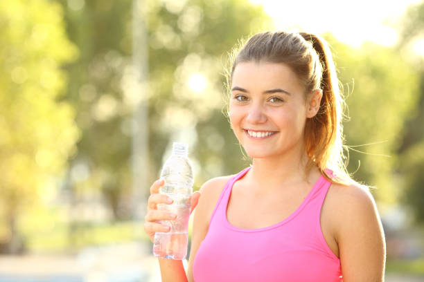 istock Happy runner looks at camera holding a water bottle 1184341073