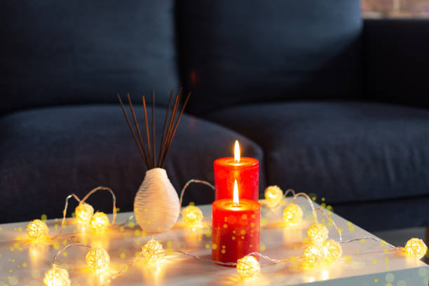 istock Room air refresher sticks and red burning candles on table on home modern interior. 1184342399