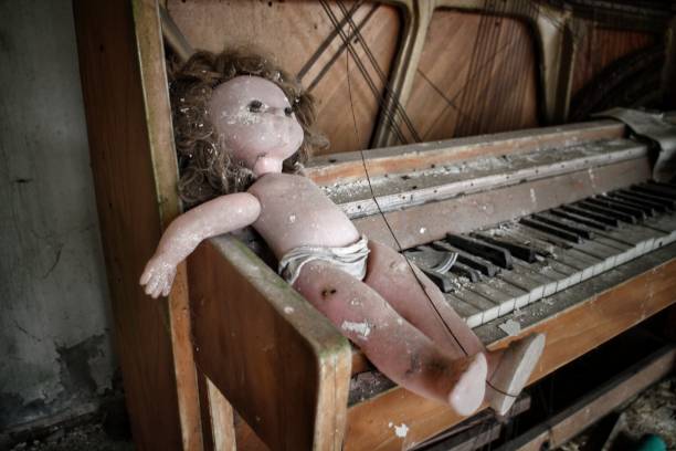 istock Creepy doll on a piano 1184342978