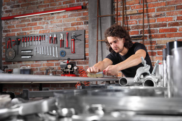 istock man in home workshop garage work metal with handle wire brush, repair, brushes and cleaning iron pipe on the workbench full of wrenches, diy and craft concept 1184347985