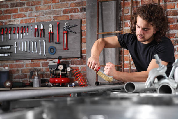 istock man in home workshop garage work metal with handle wire brush, repair, brushes and cleaning iron pipe on the workbench full of wrenches, diy and craft concept 1184347987