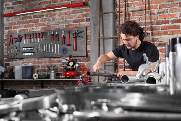 istock man work in home workshop garage with steel file rasp, filing metal pipe on the workbench full of wrenches, diy and craft concept 1184347988