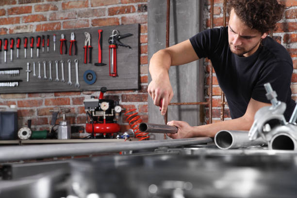 istock man work in home workshop garage with steel file rasp, filing metal pipe on the workbench full of wrenches, diy and craft concept 1184347991