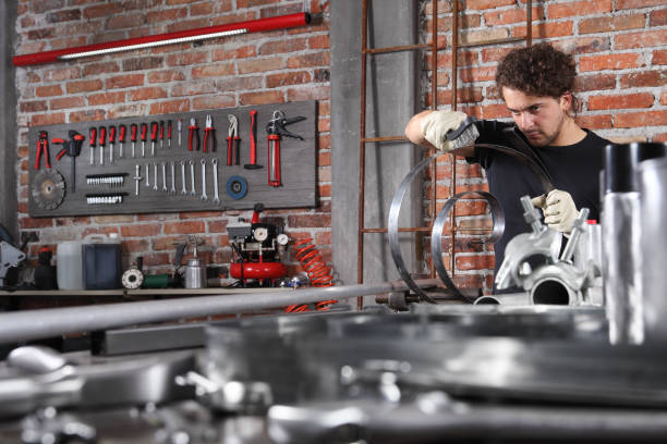 istock man in home workshop garage work metal with handle wire brush, repair, brushes and cleaning iron spring spiral on the workbench full of wrenches, diy and craft concept 1184348003