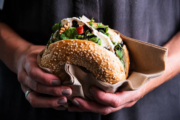 istock Woman is  holding a bagel fresh burger before eating. 1184348988