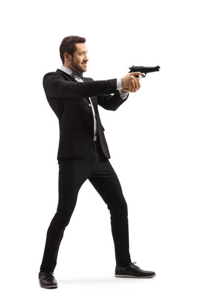 istock Man in a suit aiming with a gun 1184349003
