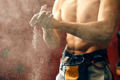 Man coating his hands in powder chalk magnesium preparing to climb, motion