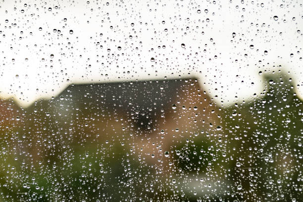 istock Suburban house viewed through a window on a rainy day 1184350005