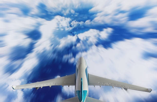 The travel by plane flies in the sky above the clouds.