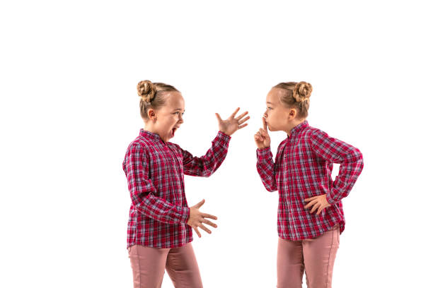 istock Young handsome girl arguing with herself on white studio background. 1184353628