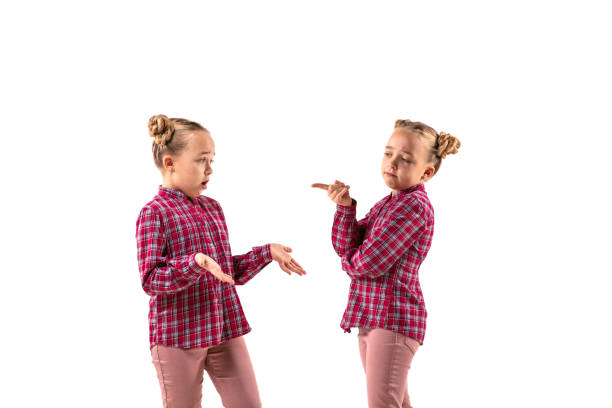 istock Young handsome girl arguing with herself on white studio background. 1184353631