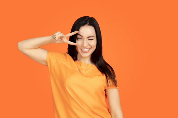 istock Caucasian young woman's portrait on orange background 1184354251